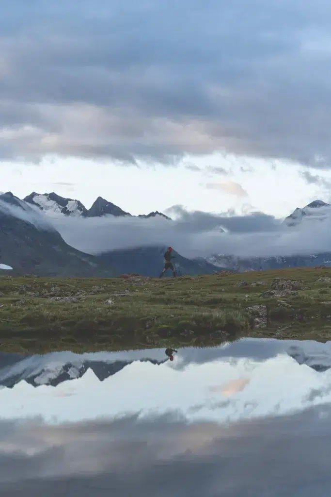 Eine Person spaziert an einem See, Berge und Wolken spiegeln sich - perfekt für Trailrunning im Ötztal.
