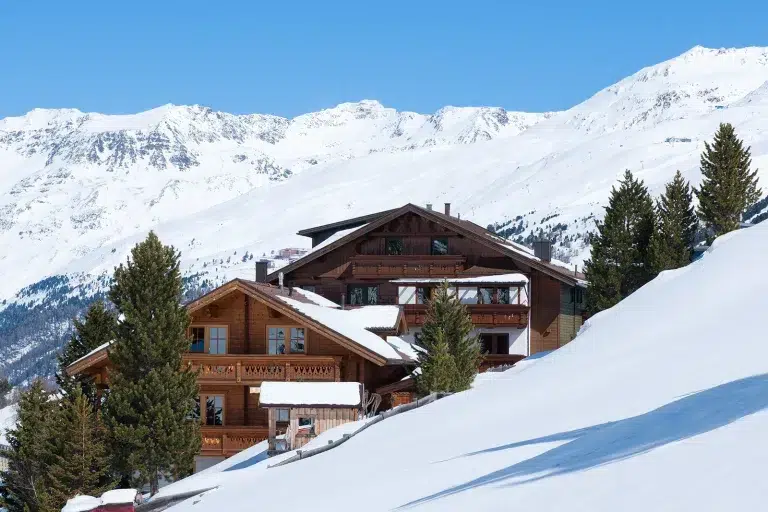 Holzchalet in der Nähe von verschneiten Bergen und Kiefern, nahe der Frühstückspension s'Hoamatl.