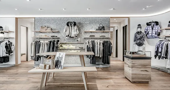 Modernes Bekleidungsgeschäft von Snow Society mit Jacken, Pullovern und stilvollen Holzauslagen.