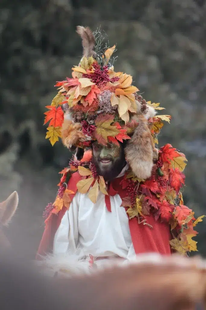 Person im Herbstlaubkostüm mit Pelz, lächelnd an Fasnacht in Telfs im Freien.