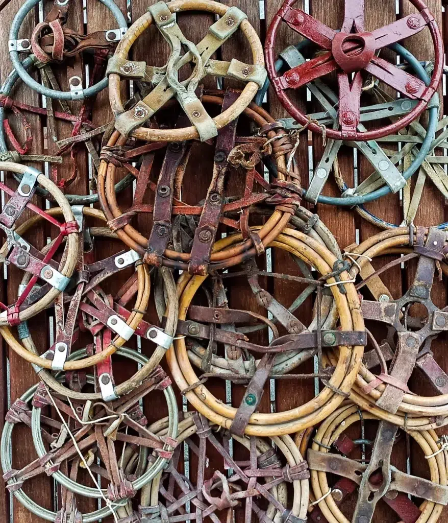 Die Sammlung alter Holz- und Metallschneeschuhe eines Skiinfluencers an einer Holzwand.