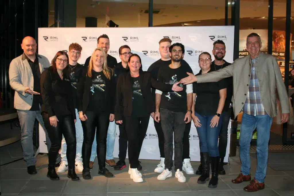 Eine Gruppe lächelt und posiert gemeinsam vor der Kulisse der Veranstaltung Jubiläum 10 Jahre Filiale Telfs.