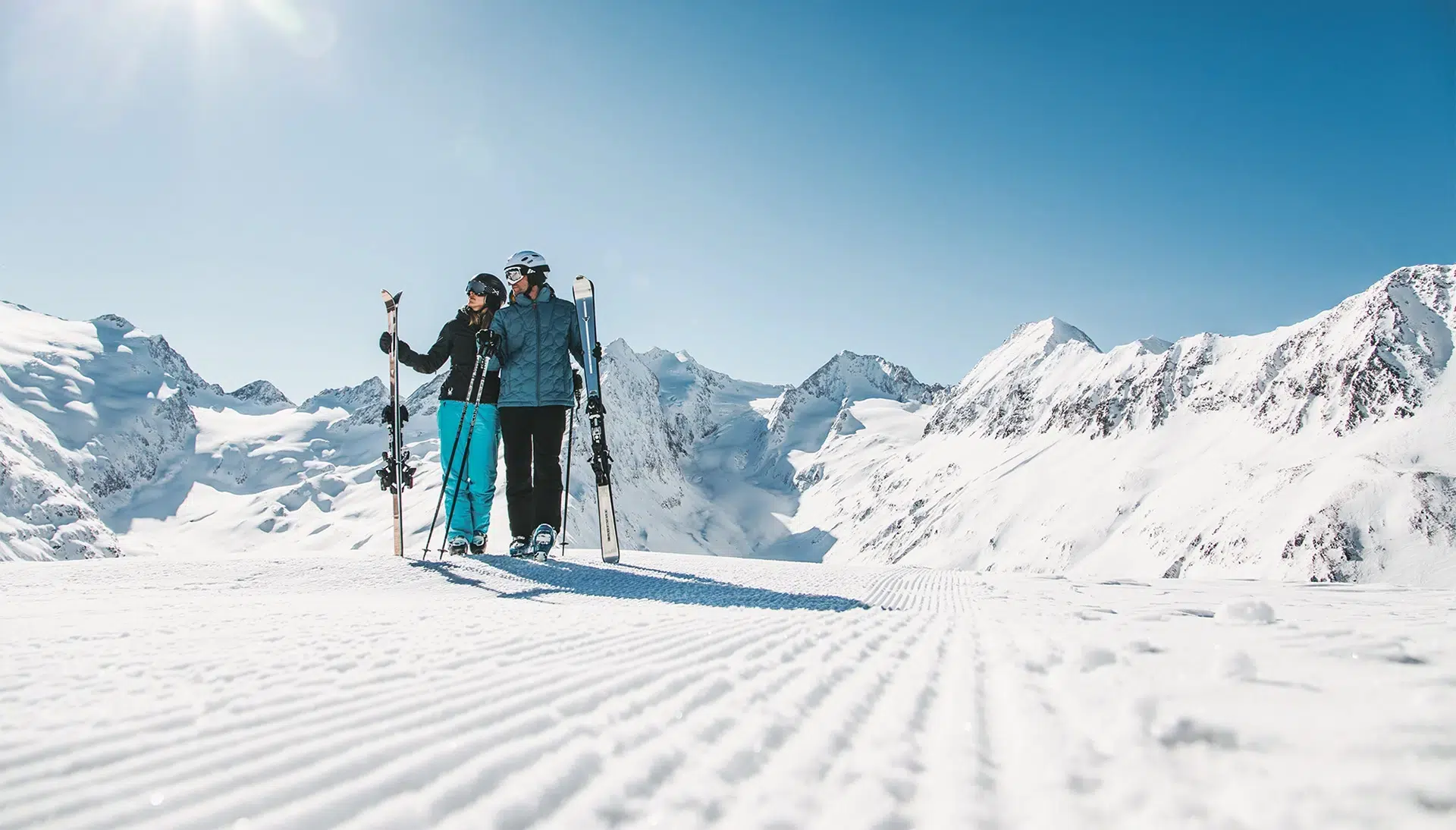 Zwei Skifahrer stehen auf einer verschneiten Piste und genießen die Gipfel im Rahmen der Snow Society.