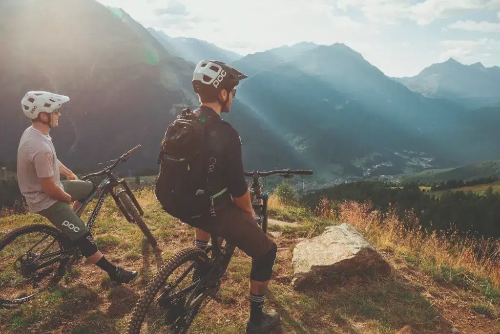 Zwei Mountainbiker auf einer landschaftlich reizvollen Talfahrt, die durch Bike-Leasing zum Abenteuer werden.