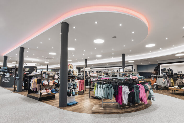 Modernes Bekleidungsgeschäft in Riml Sports Telfs mit geordneten Regalen und heller Beleuchtung.